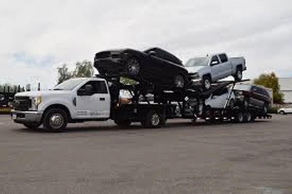 Pickup truck pulling a gooseneck hot shot trailer loaded with vehicles